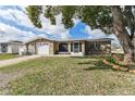 Charming home featuring a paved driveway, well-maintained lawn and mature tree providing nice curb appeal at 9201 Lunar Ln, Port Richey, FL 34668