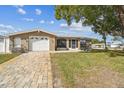 Charming home featuring a paved driveway, well-maintained lawn and mature tree providing nice curb appeal at 9201 Lunar Ln, Port Richey, FL 34668