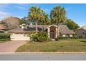 Charming home featuring palm trees, well-manicured landscaping, and a two-car garage at 9405 Ashley Dr, Weeki Wachee, FL 34613