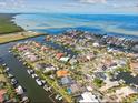 Aerial view of waterfront homes with boat docks and a large bay in the background at 944 Symphony Isles Blvd, Apollo Beach, FL 33572