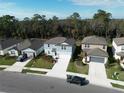 View of the blue house on a tree-lined street showing surrounding landscape and neighboring properties at 11751 Moonsail Dr, Parrish, FL 34219