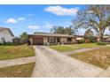 Quaint single-story home featuring a stone facade, well-maintained lawn, and a long driveway at 1314 Oak Valley Dr, Seffner, FL 33584