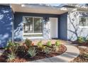 Inviting front porch with tasteful landscaping, brick walkway and a welcoming entrance at 1545 Pasadena Dr, Dunedin, FL 34698