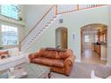 Cozy living room featuring a grand staircase, large windows, and a view of the kitchen at 320 Georgia Ave, Crystal Beach, FL 34681