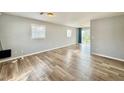 Bright living room featuring hardwood floors, large windows, and sliding glass doors to the backyard at 3902 W Iowa Ave, Tampa, FL 33616