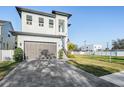 A gray brick driveway leads up to the two-car garage of this bright two story home at 619 Danube Ave, Tampa, FL 33606