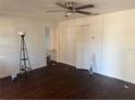 Open concept living room with dark laminate wood flooring, a ceiling fan, and natural light at 6347 S Lansdale Cir, Tampa, FL 33616