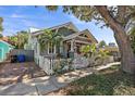 Charming home featuring a picket fence, lush landscaping, and a cozy front porch with a red front door at 731 7Th N St, St Petersburg, FL 33701