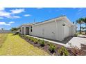 The side of the home features manicured landscaping, white exterior walls, and a gray paver driveway at 8089 Shore Lake Dr, Englewood, FL 34224