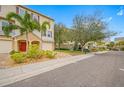Street view of townhomes featuring well-maintained landscaping and attached garages in a community setting at 876 Callista Cay Loop, Tarpon Springs, FL 34689