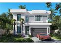 Modern home featuring clean lines, large windows, and a gray garage door, complemented by lush landscaping at 902 W Fribley St, Tampa, FL 33603