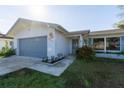 Charming single-story home featuring an attached garage and lovely landscaping at 1091 Mcfarland St, Dunedin, FL 34698