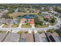 Panoramic aerial view of a home with a screened pool, surrounded by mature trees and a tranquil pond at 12333 Woodlands Cir, Dade City, FL 33525