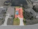 Aerial view showcasing the home's layout, screened-in pool, verdant landscaping, and neighborhood context at 12333 Woodlands Cir, Dade City, FL 33525