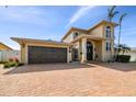 Beige two-story home boasting an arched front door, brick driveway, and attached two-car garage at 1336 51St Ne Ave, St Petersburg, FL 33703