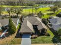 Aerial view of a one-story house with lush green lawn, mature trees, and an extended driveway at 1401 Ventana Dr, Sun City Center, FL 33573