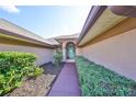 Charming walkway leading to a welcoming turquoise front door, framed by lush greenery at 1401 Ventana Dr, Sun City Center, FL 33573