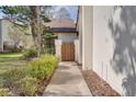 A charming courtyard entrance with a gate and a walkway leading to the front door at 14810 Feather Cove Ln, Clearwater, FL 33762