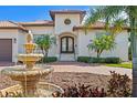 Elegant front entrance featuring a decorative fountain, mature palms, and a double-door entry at 2028 Illinois Ne Ave, St Petersburg, FL 33703