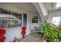 Cozy front porch area with flagstone, a small table, and chairs, perfect for relaxing outdoors at 2086 Whitney N Pl, Clearwater, FL 33760