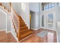 Inviting foyer with hardwood flooring, staircase, and ample natural light from the double door entry at 212 Arbor Woods Cir, Oldsmar, FL 34677