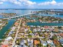 Stunning aerial view of waterfront community near a bridge and the bay, boasting luxury homes at 230 Julia S Cir, St Pete Beach, FL 33706