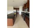 Spacious kitchen featuring dark wood cabinets, stainless steel appliances, and a large island at 2827 Shetland Ridge Dr, Valrico, FL 33596