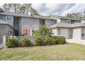 A well-kept two-story townhome with lush landscaping and a cozy front patio area at 388 Buckingham Pl, Palm Harbor, FL 34684