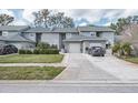 Two-story townhome with attached garages and a well-maintained front lawn on a sunny day at 388 Buckingham Pl, Palm Harbor, FL 34684