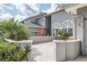 Inviting patio area with brick pavers, a low wall, and tropical landscaping at 388 Buckingham Pl, Palm Harbor, FL 34684