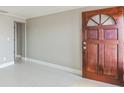 Inviting entryway with a solid wood door, neutral paint, and sleek tile flooring at 3939 Rudder Way, New Port Richey, FL 34652