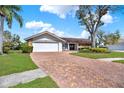 Charming single-story home featuring a manicured lawn and beautiful brick driveway at 4309 Deepwater Ln, Tampa, FL 33615