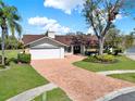 Charming single-story home featuring a manicured lawn and beautiful brick driveway at 4309 Deepwater Ln, Tampa, FL 33615