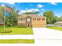 Charming home with a manicured lawn, American flag, and a convenient three-car garage at 5147 Elwood Rd, Spring Hill, FL 34608