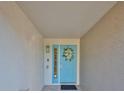 Front entryway with a light blue door, transom window, and floral wreath at 521 Pinellas Bayway S # 104, St Petersburg, FL 33715