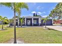 Beautiful single-story home with a well-manicured lawn and mature landscaping, enhanced by palm trees at 7609 Clair Wood Ct, Apollo Beach, FL 33572