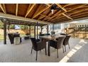 Inviting covered patio features a wooden ceiling, a rustic dining table and wicker chairs for alfresco dining and entertaining at 1012 W Berry Ave, Tampa, FL 33603