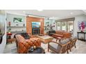 Bright living room featuring a cozy fireplace, leather sofas, and chic decor at 105 Country Villas Dr, Safety Harbor, FL 34695
