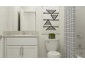 Modern bathroom showcasing a granite countertop, white cabinetry, and stylish geometric art above the toilet at 11243 E 65Th Ter, Palmetto, FL 34221