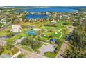 Aerial view of the local park with tennis courts, playground, open space and a picturesque lake beyond at 130 81St Ne Ave, St Petersburg, FL 33701