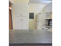 Eat-in kitchen features white cabinets and appliances at 1308 Pine Ridge E Cir # E3, Tarpon Springs, FL 34688