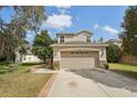 Attractive home with a two-car garage, stone veneer accents, and a well-maintained lawn at 15701 Greyrock Dr, Spring Hill, FL 34610