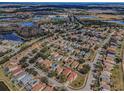Aerial view of a residential neighborhood with homes, trees, lakes, and a school at 19609 Timberbluff Dr, Land O Lakes, FL 34638