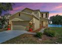 Home's front exterior featuring a red tiled roof, stucco facade, stone accents, and a two-car garage at 19609 Timberbluff Dr, Land O Lakes, FL 34638