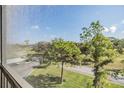A scenic balcony view of lush greenery, mature trees, and a glimpse of the surrounding landscape at 2700 Cove Cay Dr # 4-B, Clearwater, FL 33760