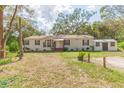 Well-kept single-story home with a tidy front yard and an auxiliary structure on the right side of the house at 36246 Peak St, Zephyrhills, FL 33541