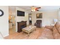 Comfortable living room featuring wood floors, a fireplace, and an open flow to the adjacent spaces at 36246 Peak St, Zephyrhills, FL 33541