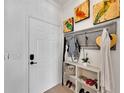 Bright entryway with a white door, coat rack, and colorful bird artwork creating an inviting welcome at 5000 Culbreath Key Way # 9-102, Tampa, FL 33611
