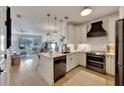 Open kitchen with white cabinets, stainless steel appliances, and a center island, seamlessly flowing into the living area at 5000 Culbreath Key Way # 9-102, Tampa, FL 33611