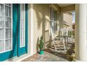 Inviting front porch with rocking chairs, a paver floor, and white columns, creating a relaxing outdoor space at 5229 Brighton Shore Dr, Apollo Beach, FL 33572